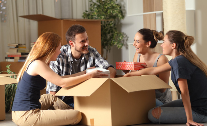 Friends unboxing belongings together after moving into a new house.
